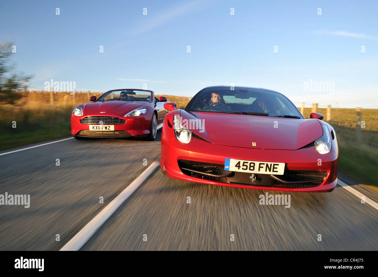 Ferrari 458 Italia et Aston Martin Virage route côte à côte au coucher du soleil Banque D'Images