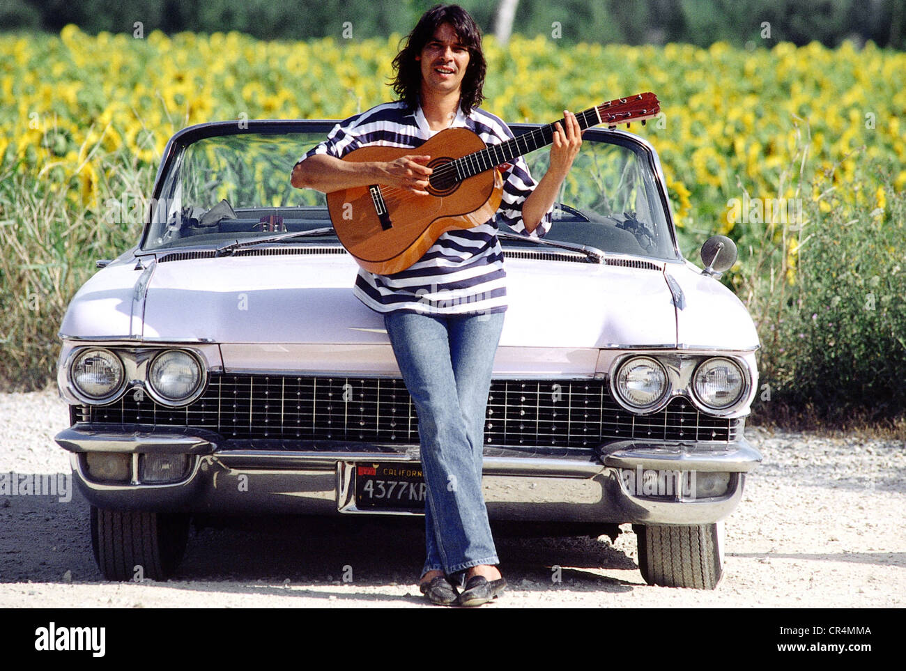 Gypsy Kings, groupe de musique française, Canut Reyes, membre du groupe, avec guitare, pleine longueur devant sa voiture, Arles, France, 1988, Banque D'Images