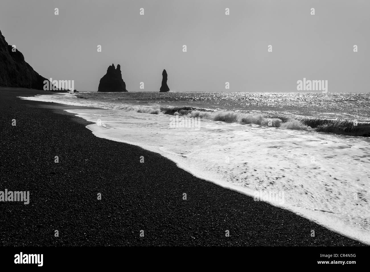 Du sable et de la mer Noire des structures rock pile au large de la plage de Vik sur une journée ensoleillée, l'Islande, Scandinavie Banque D'Images