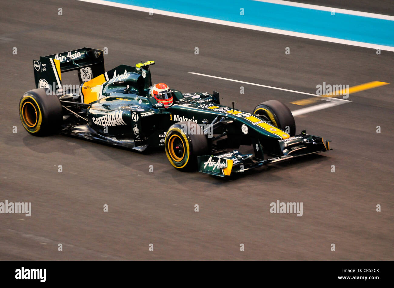 Les voitures de course de Formule 1 Jarno Trulli, Italie, démarrer le numéro 21, de l'équipe Lotus-Renault sur la piste de course du Circuit de Yas Marina Banque D'Images