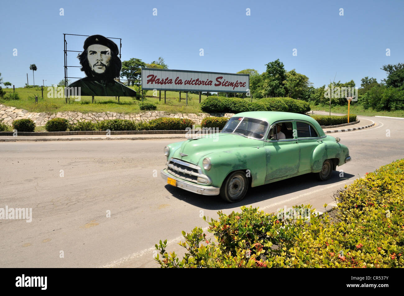 Vintage car en face de la propagande révolutionnaire, 'hasta la victoria siempre', espagnol pour "toujours de l'avant à la victoire" avec Banque D'Images