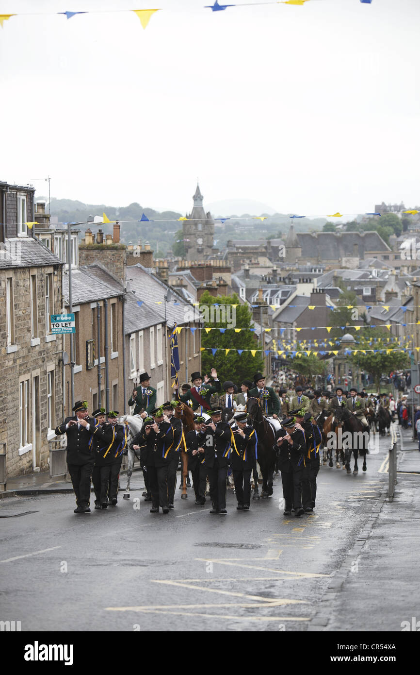 Le Cornet et supporters suivre derrière bande Fife & Drum à l'amarrer au cours de Hawick Common-Riding dans la ville frontière, Ecosse Banque D'Images