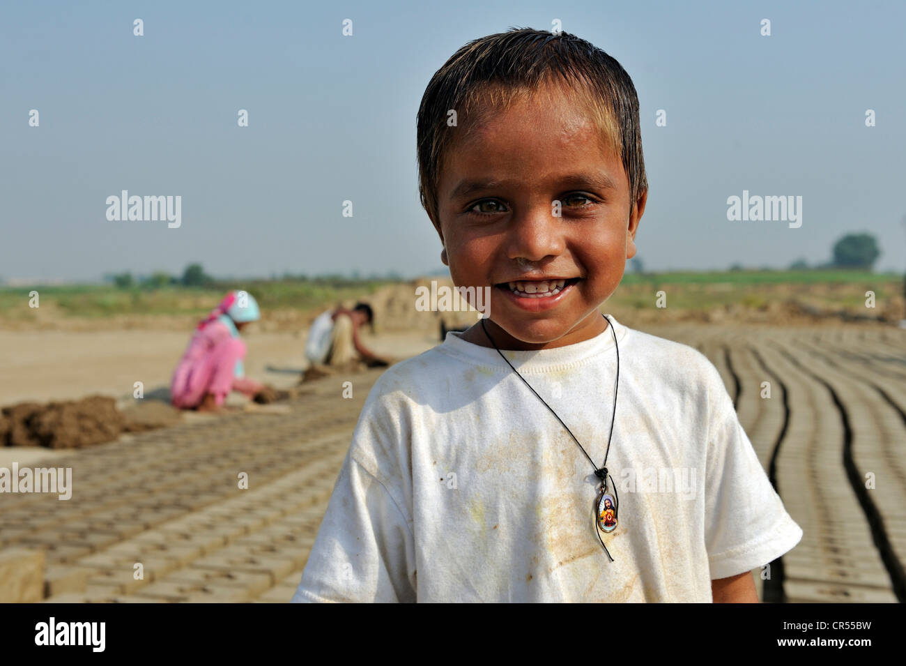 Smiling boy dans une briqueterie, la plupart des travailleurs appartiennent à la minorité chrétienne au Pakistan et sont particulièrement touchés Banque D'Images