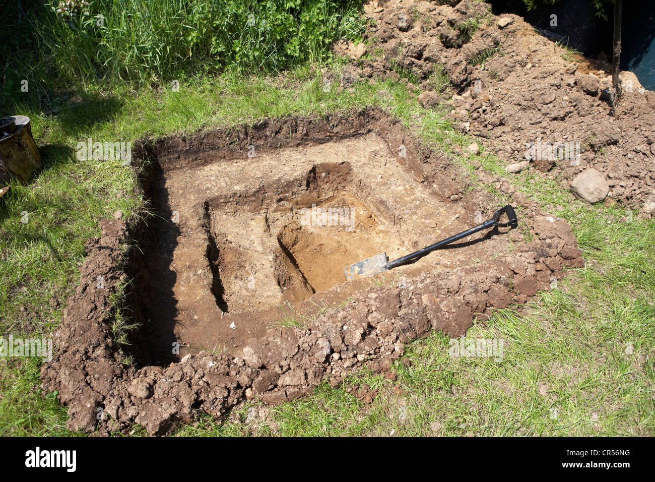 Creuser un trou pour construire un étang dans un jardin au Royaume-Uni Banque D'Images