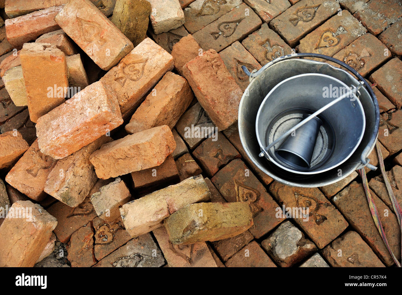 Bricks, bécher et l'eau des seaux, site de construction d'un canal d'irrigation, Lehar Basti Walla village, Punjab, Pakistan, Asie Banque D'Images