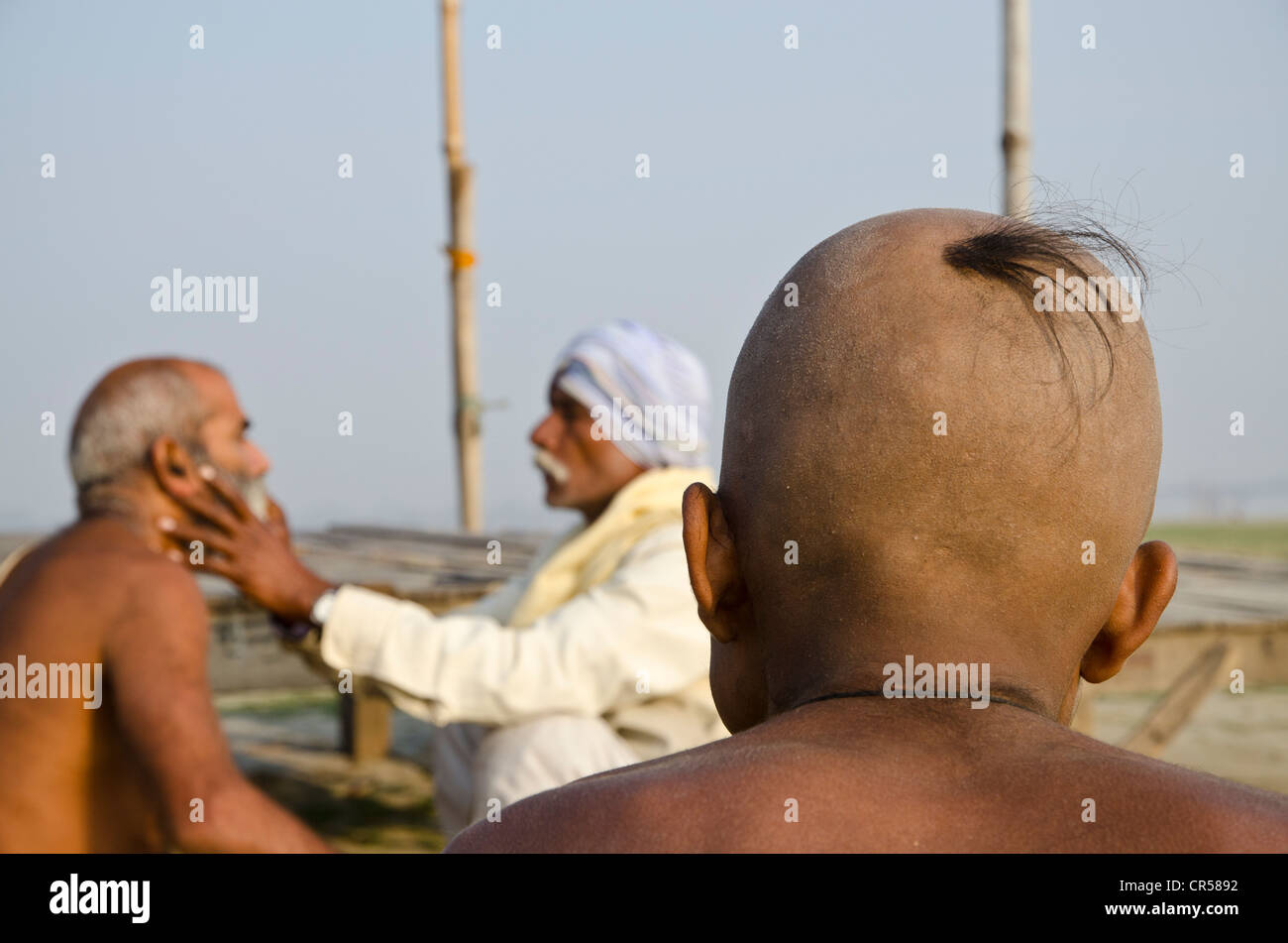 La tête de rasage dans le cadre d'un rituel religieux, effectuée à Sangam, la confluence des rivières saint Ganges Banque D'Images