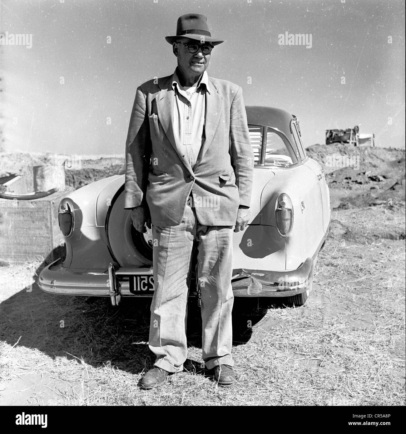 L'Afrique du Sud, années 50. Propriétaire de la mine locale Afrikaaner repose sur sa voiture. Banque D'Images