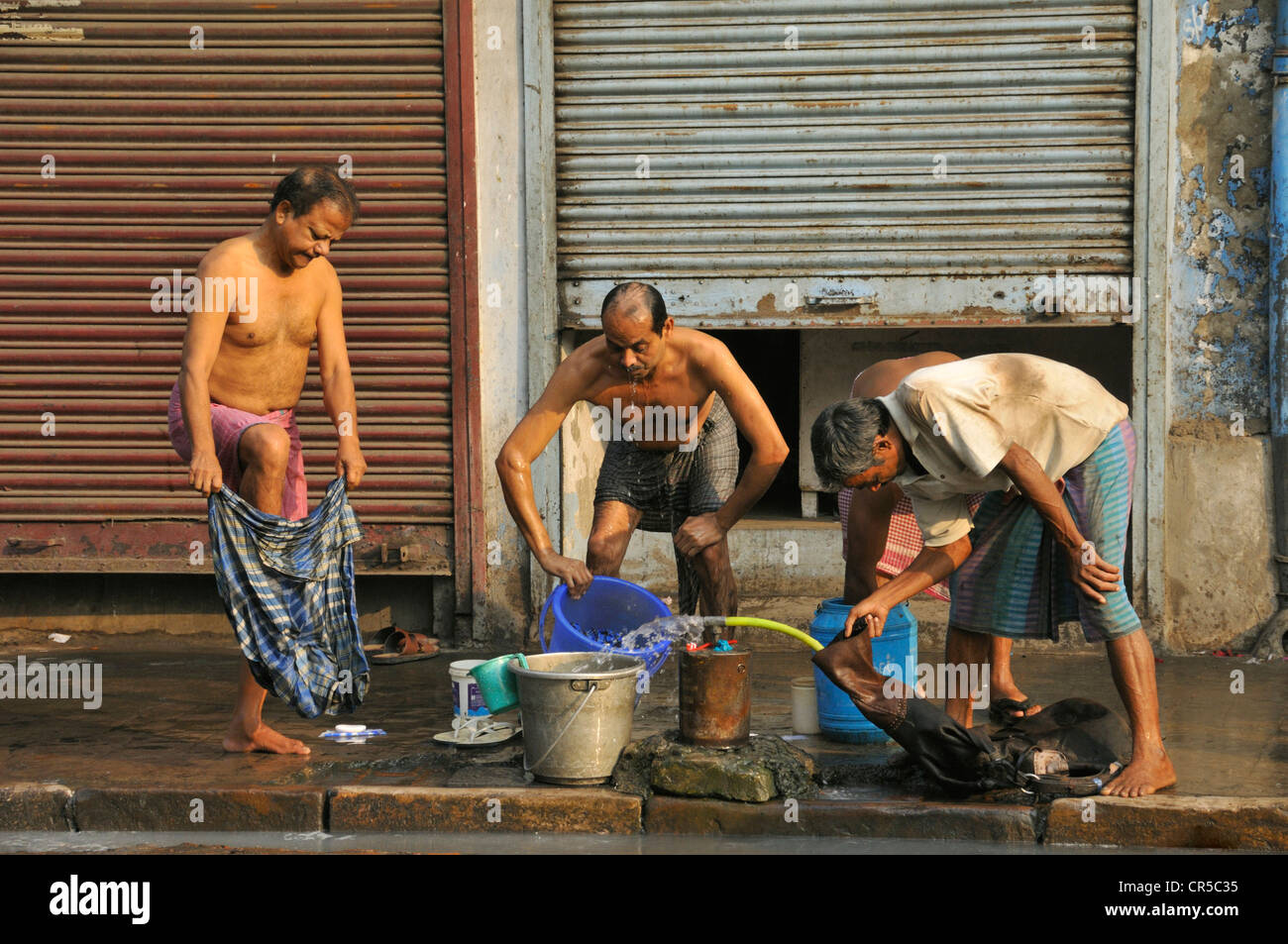 L'Inde, l'État du Bengale-Occidental, Calcutta (Kolkata), les gens se laver à un robinet public dans la rue Banque D'Images