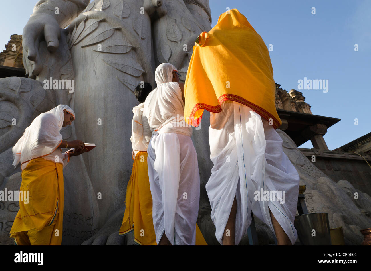 Jain sont pèlerins récitant des textes religieux au pied de la gigantesque statue de Gomateshwara , en Inde, Asie Banque D'Images