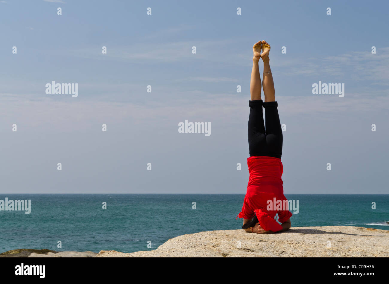 Femme dans une position de yoga, Sirshasana, par la mer de Kanyakumari, Tamil Nadu, Inde, Asie Banque D'Images