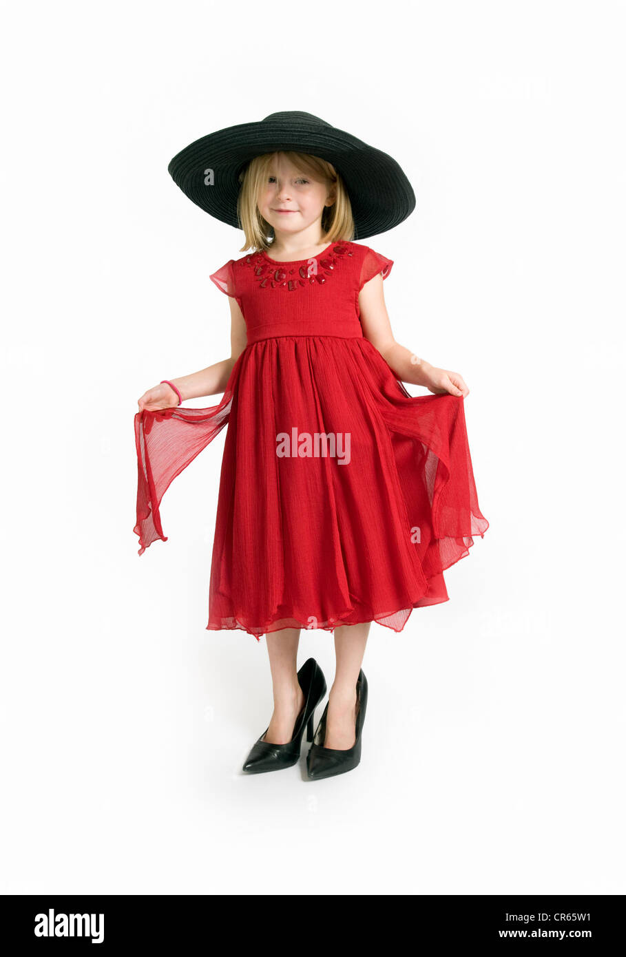 Studio image de Blancs 7 ans, fille en robe rouge jouer dress up sur un fond blanc Banque D'Images