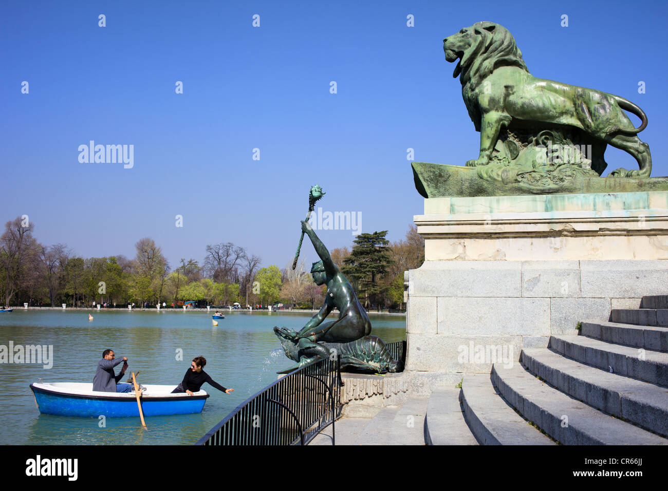 Paysage du Parc Buen Retiro à Madrid avec les touristes couple sur un bateau en prenant une photo avec des sculptures. Banque D'Images