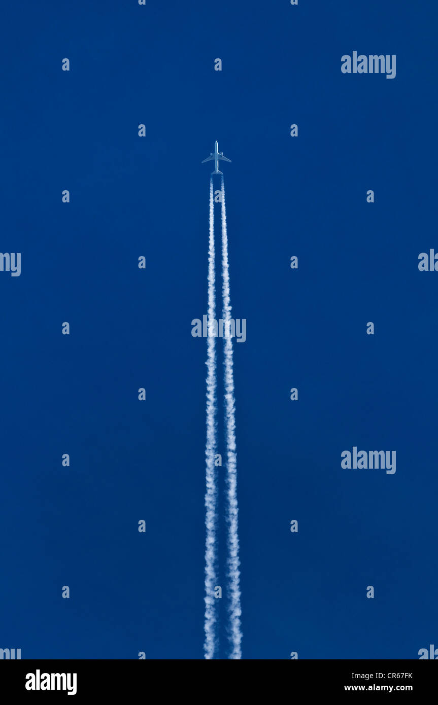 Avion avec les traînées de double dans le ciel bleu Banque D'Images Avion avec les traînées de double dans le ciel bleu Banque D'Images