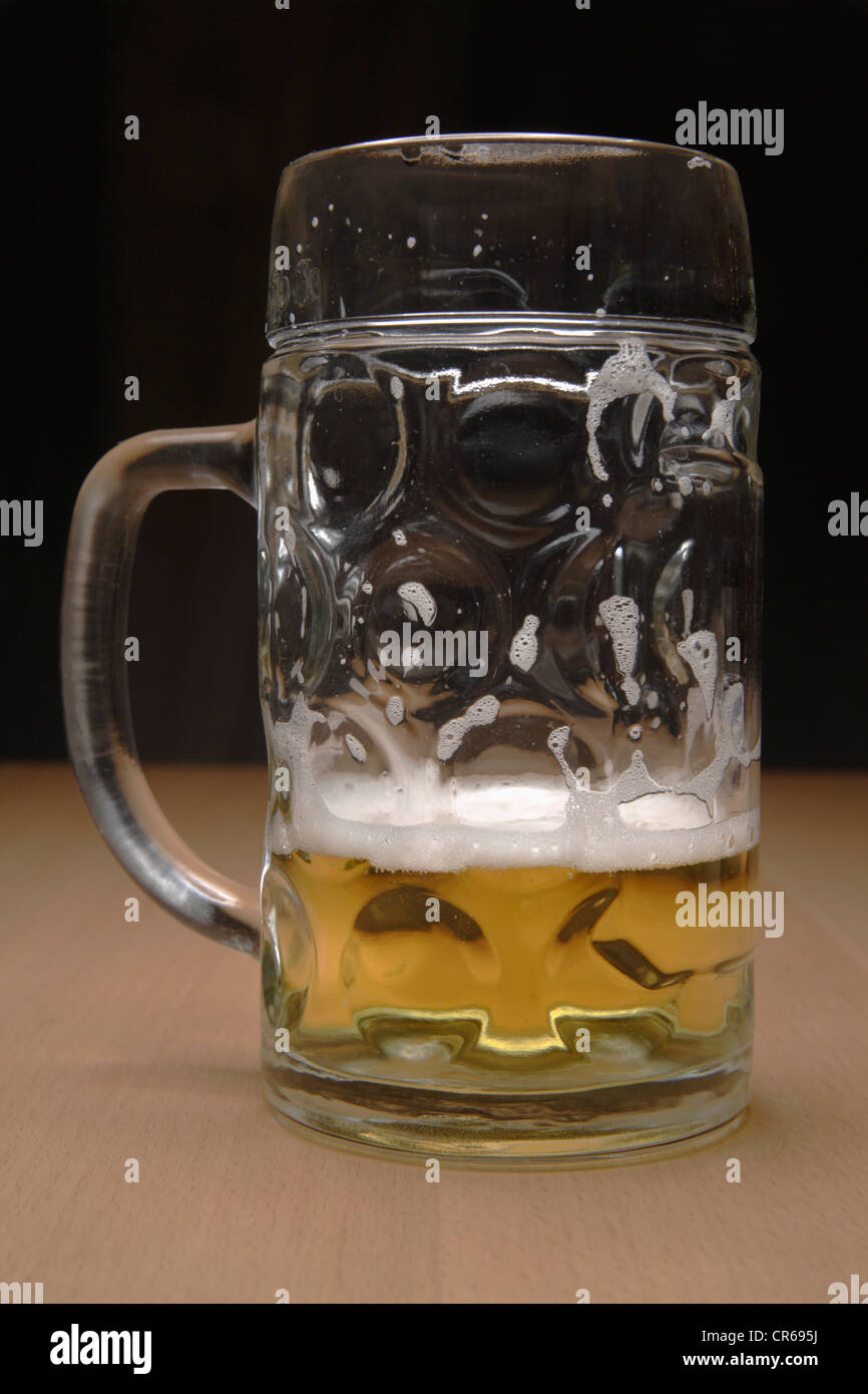 À MOITIÉ PLEIN beer mug sur la table, Close up Banque D'Images