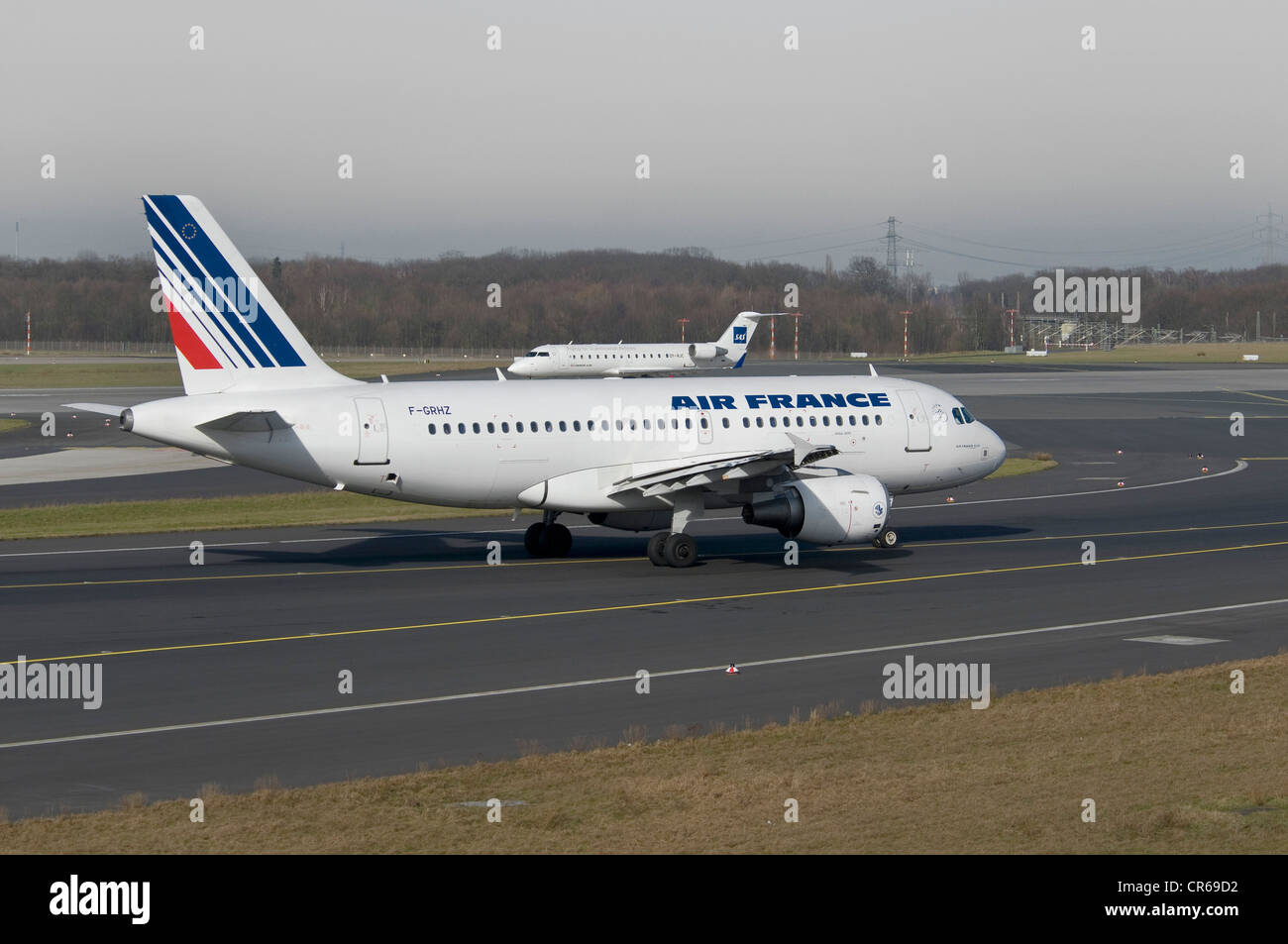 Airbus A319-111 Air France jet passagers sur la piste de l'Aéroport International de Düsseldorf, derrière, un jet SAS s'envolent Banque D'Images