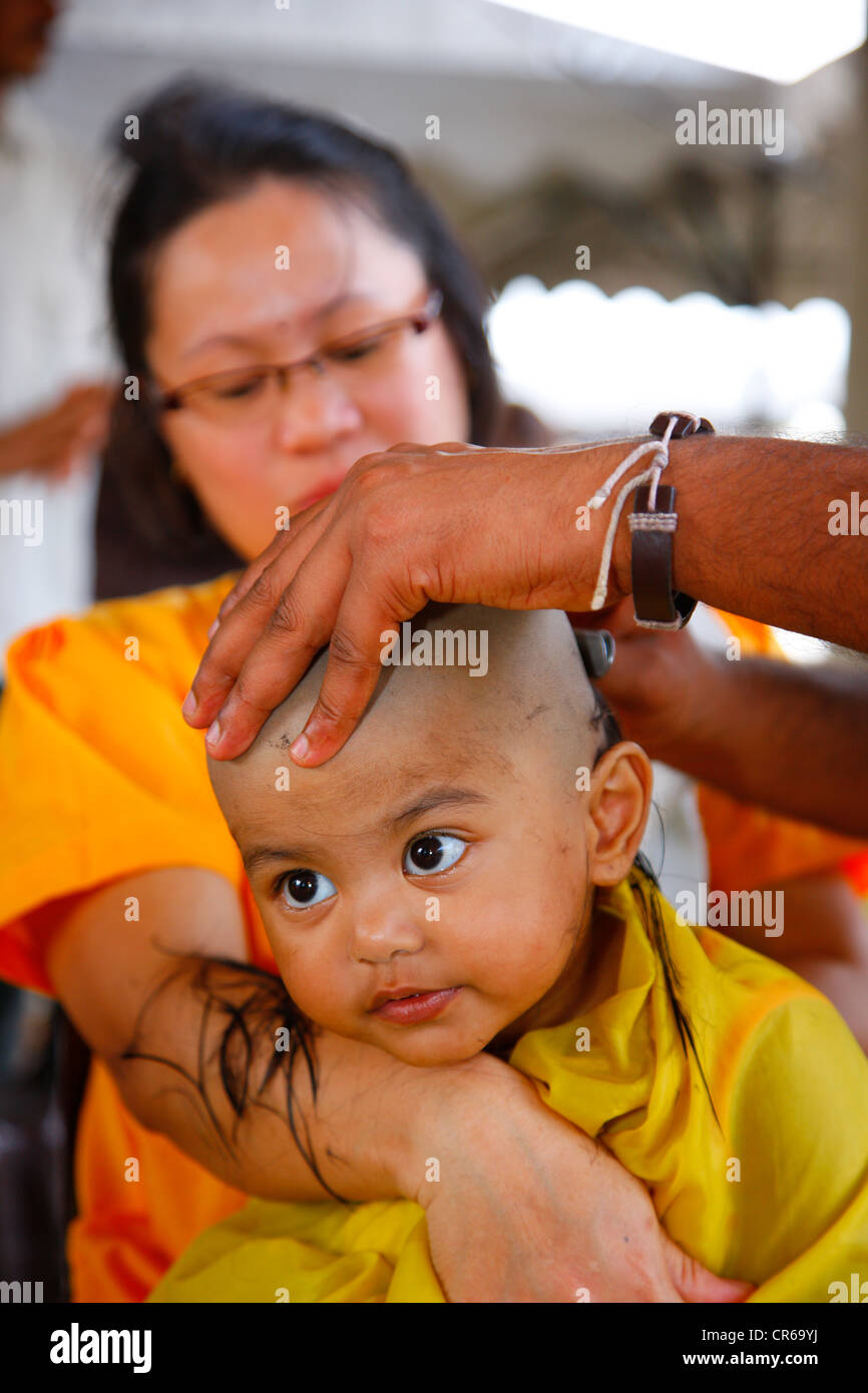 Cheveux de l'enfant d'être rasé avec un rasoir, festival hindou Thaipusam, grottes de Batu grottes calcaires et les temples, Kuala Lumpur, Malaisie Banque D'Images