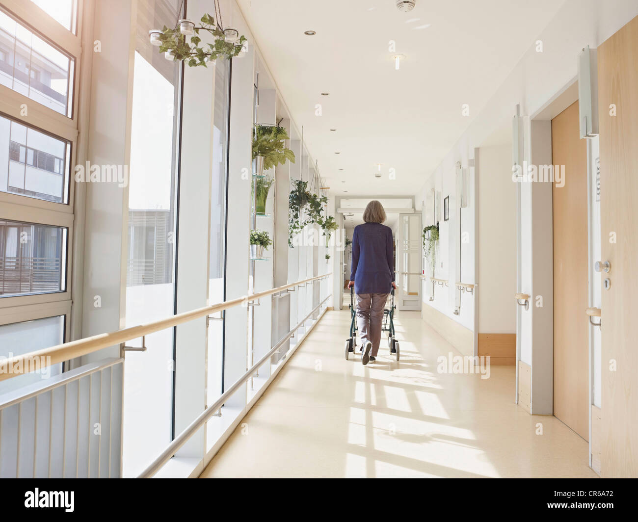 Allemagne, Cologne, Senior woman avec déambulateur à corridor dans nursing home Banque D'Images