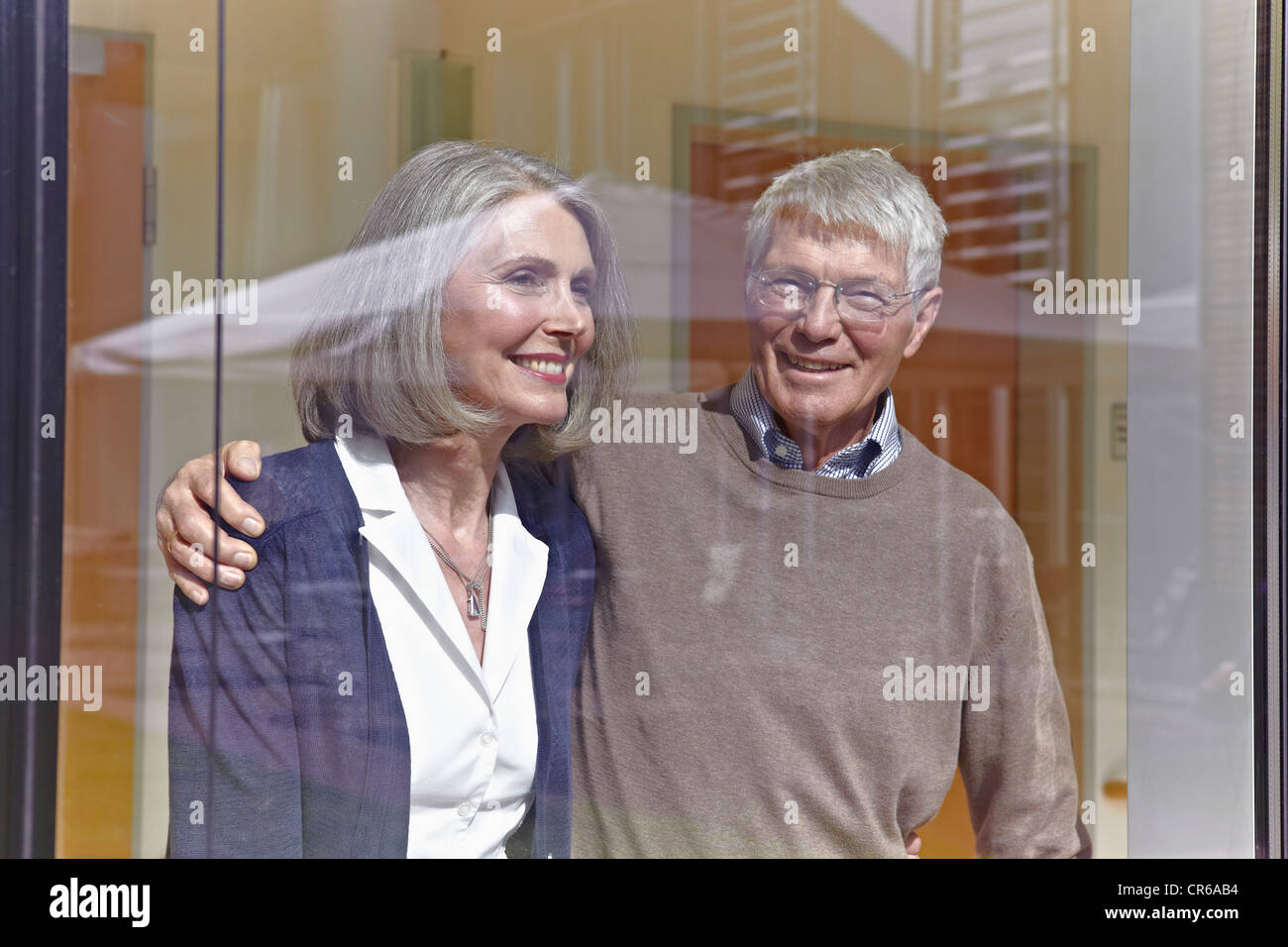 Allemagne, Cologne, Senior couple looking through window, smiling Banque D'Images