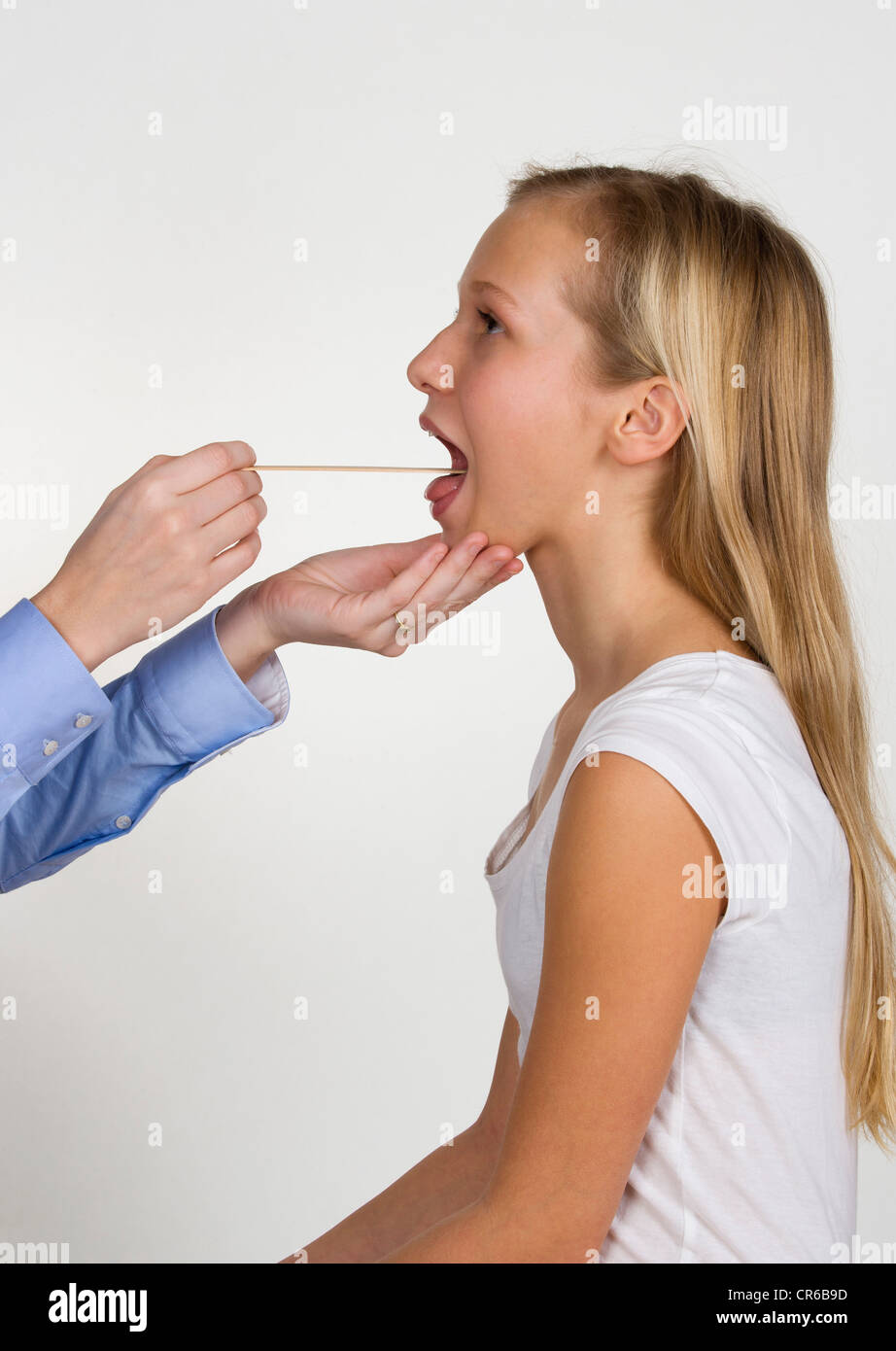 Femme médecin examinant la gorge adolescente avec abaisse-langue Banque D'Images