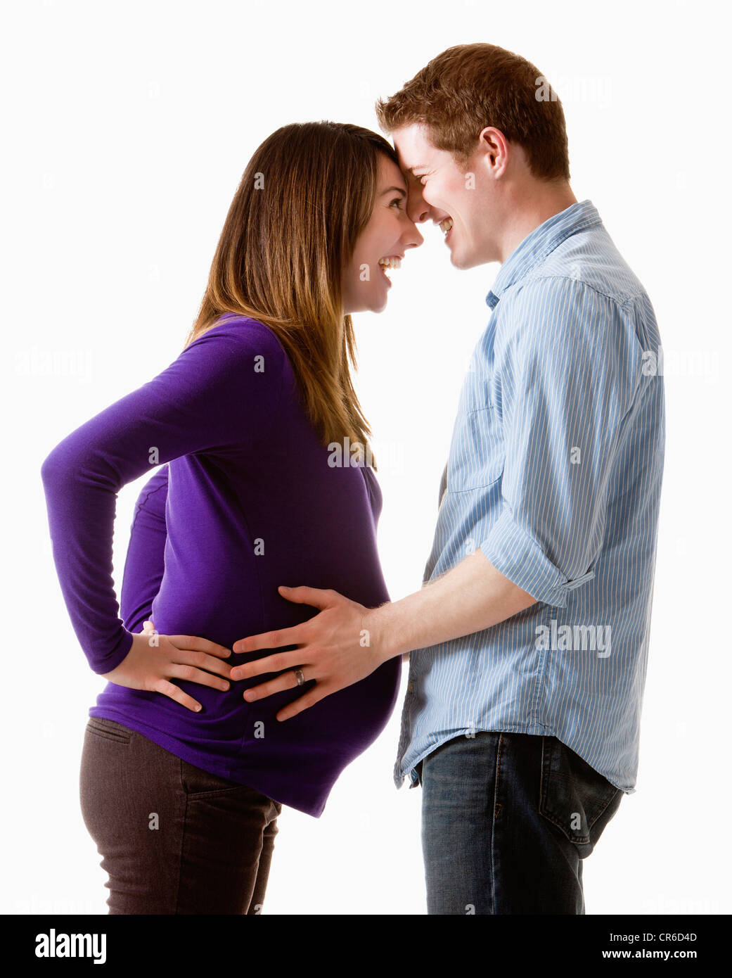 Man embracing pregnant woman, studio shot Banque D'Images