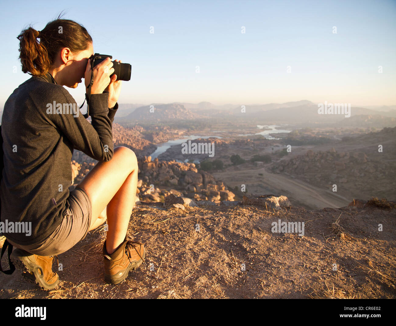 L'Inde, Karnataka, young woman photographing on haut de colline à Hampi Banque D'Images