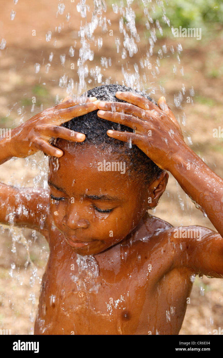 Garçon, 6, prendre une douche, Bamenda, Cameroun, Afrique Banque D'Images
