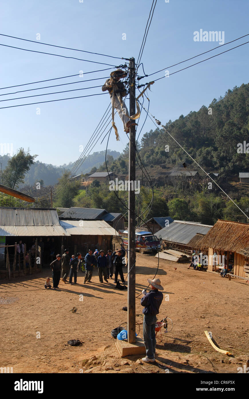 Le Laos , village Hmong Nam Kha , l'électrification des villages par lao-société allemande Sunlabob et ONG, travailleurs en colonne d'alimentation faisant le câblage d'un réseau électrique hors réseau, l'énergie provient de la petite turbine hydro Banque D'Images