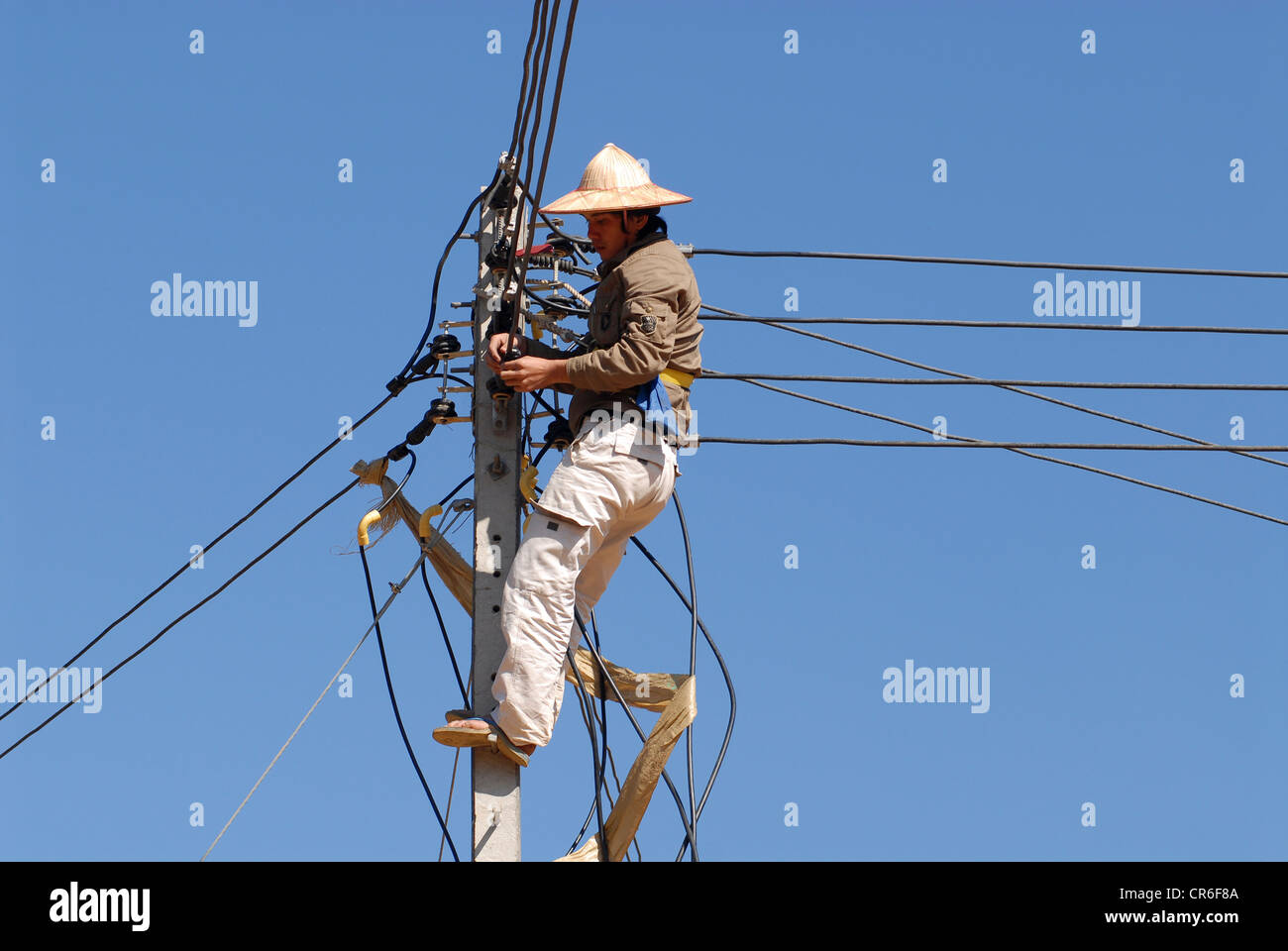 Le Laos , village Hmong Nam Kha , l'électrification des villages par lao-société allemande Sunlabob et des ONG, des travailleurs faisant câblage en colonne d'alimentation d'un off-net dieu dans le village, l'électricité est produite à partir de la petite turbine hydro Banque D'Images