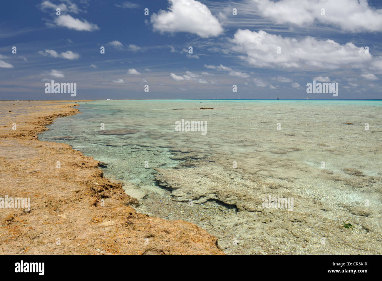 Barrière de corail, la mer turquoise et dans la distance yachts ancrés à l'intérieur du lagon formé par Minerva Reef Nord, Pacifique Sud Banque D'Images