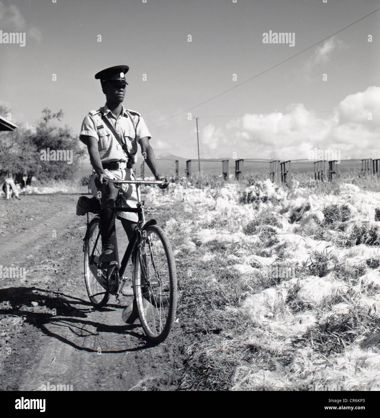 Années 1950. La Tunisie. Image historique par J Allan Paiement d'un policier du village local sur son vélo. Banque D'Images