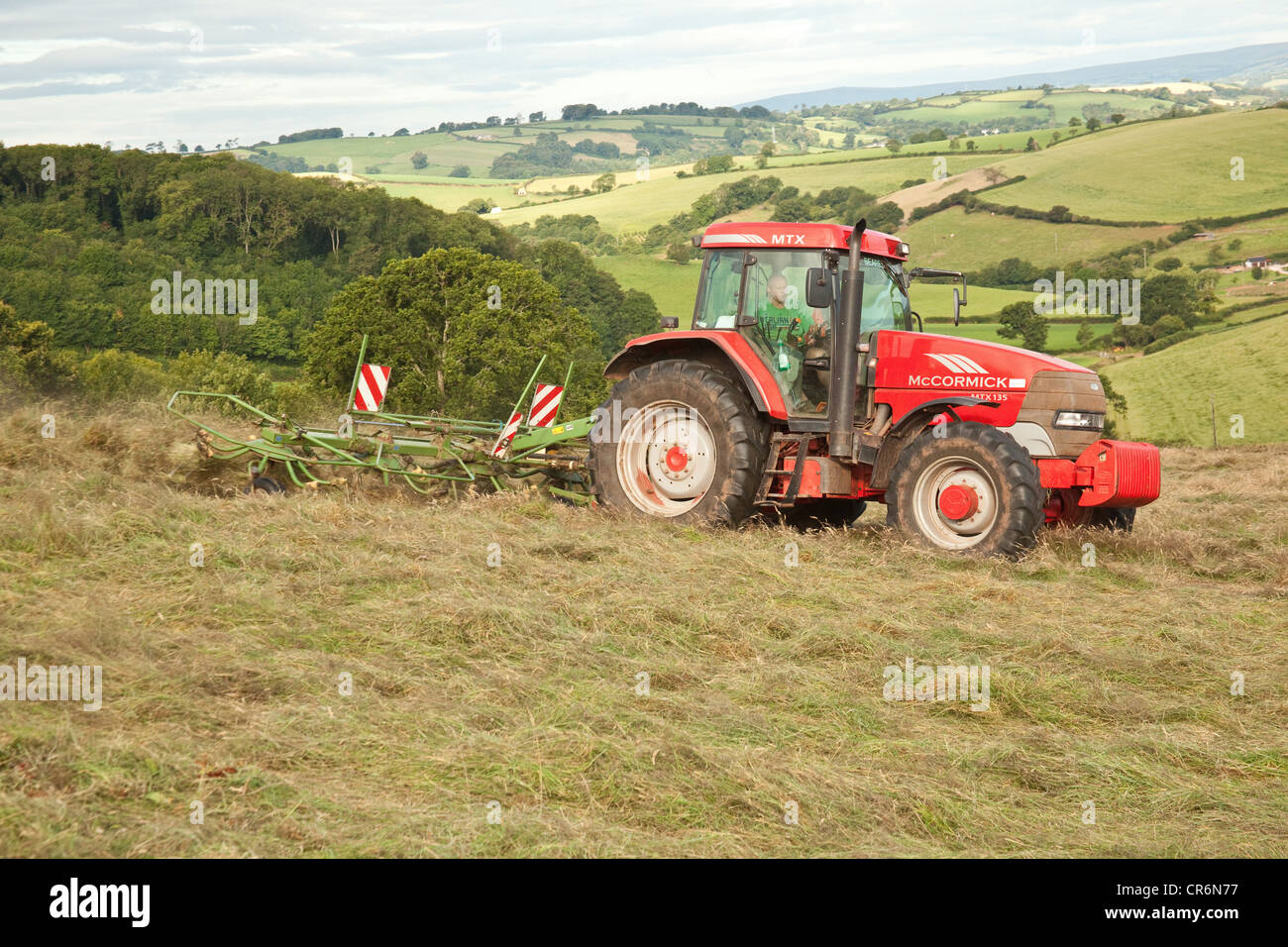 Fermier dans un tracteur le foin, South Hams hills, TOTNES, Devon, Angleterre, Royaume-Uni. Banque D'Images