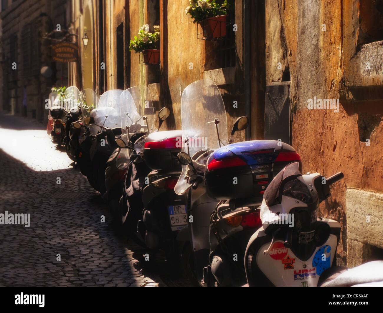 Rue pavées étroites avec une rangée de scooters, Rome, Italie Banque D'Images