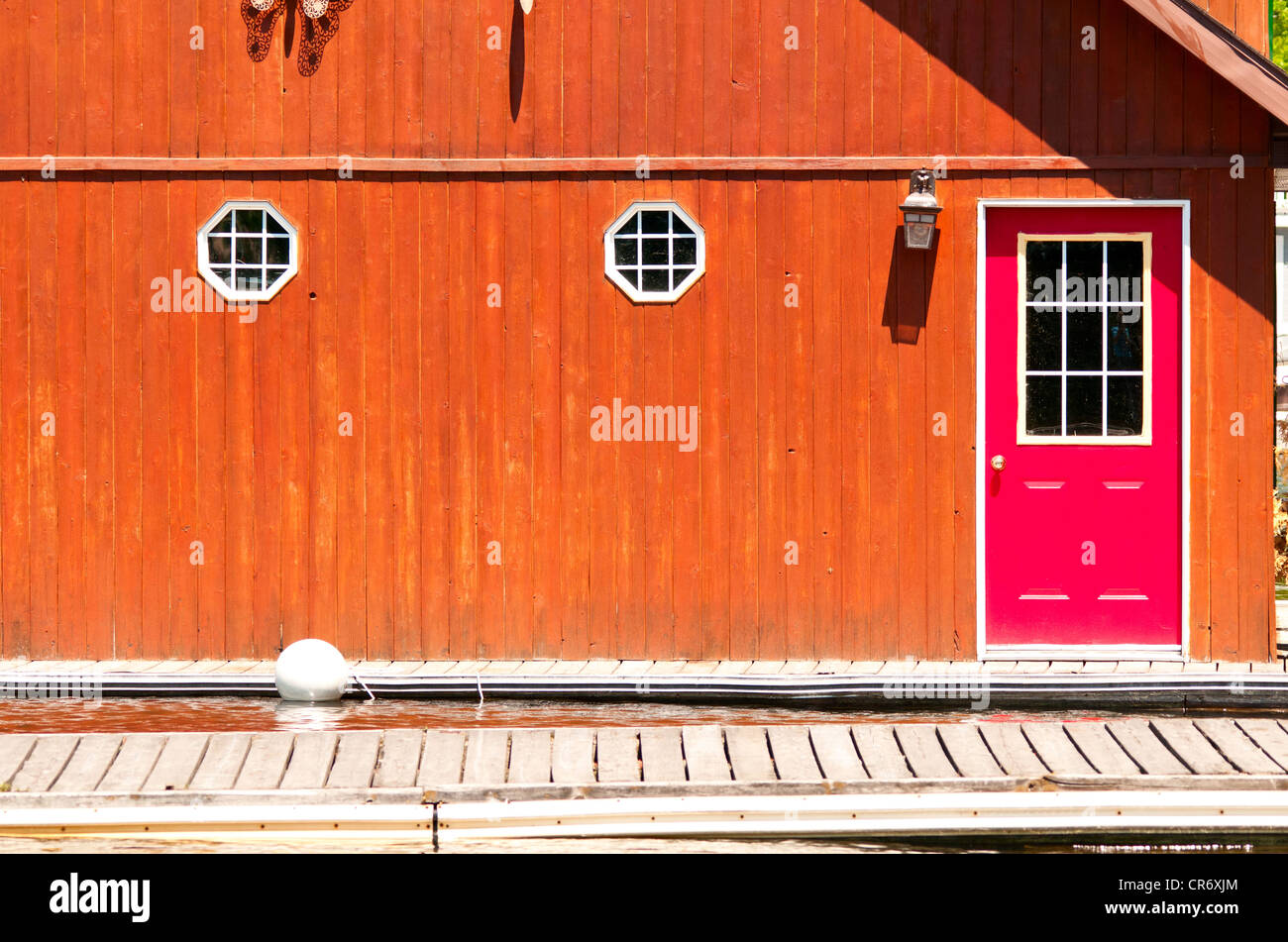 Un hangar à bateaux avec une porte rouge Banque D'Images