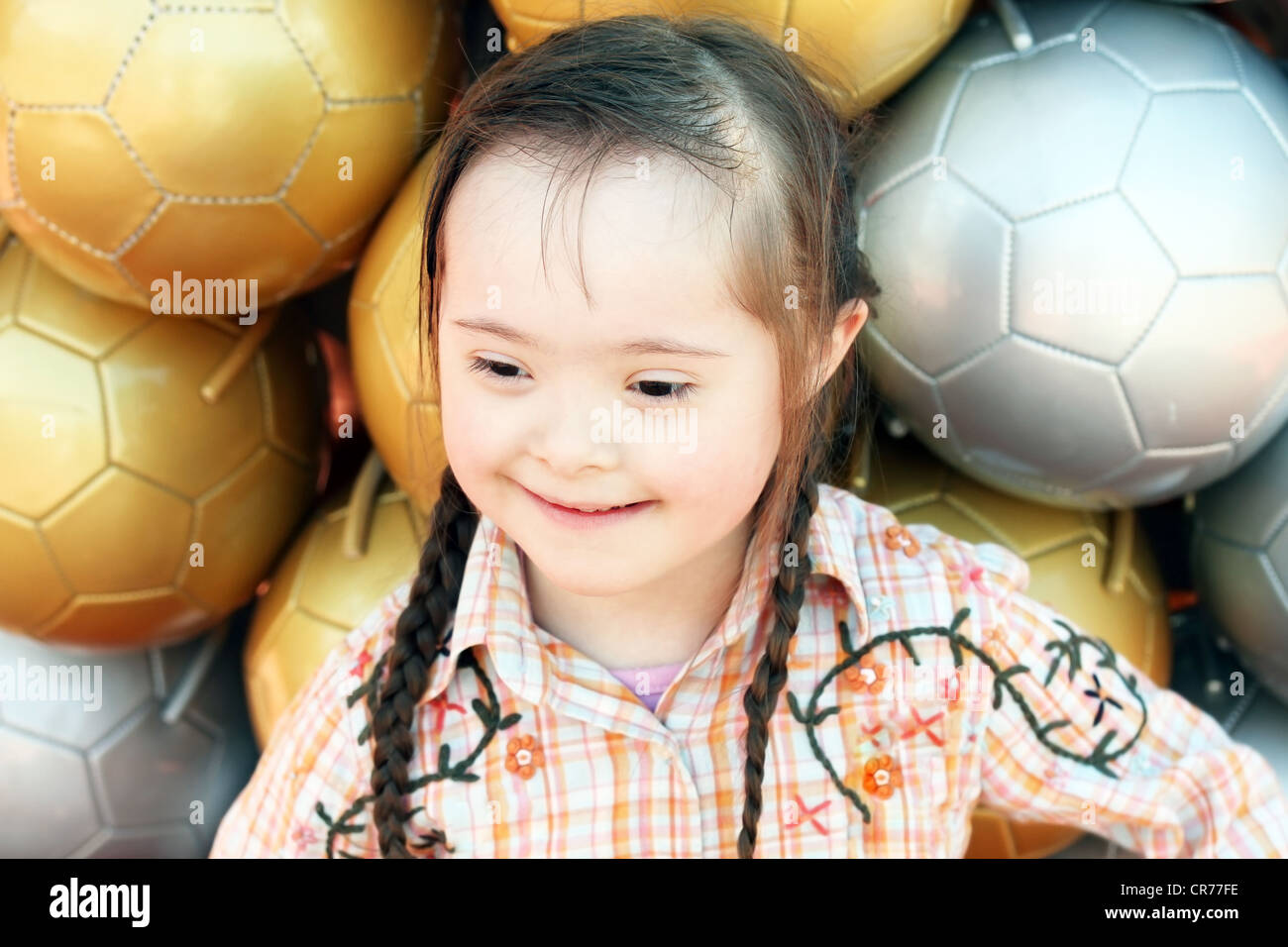 La petite fille à l'arrière-plan des ballons de soccer. Banque D'Images