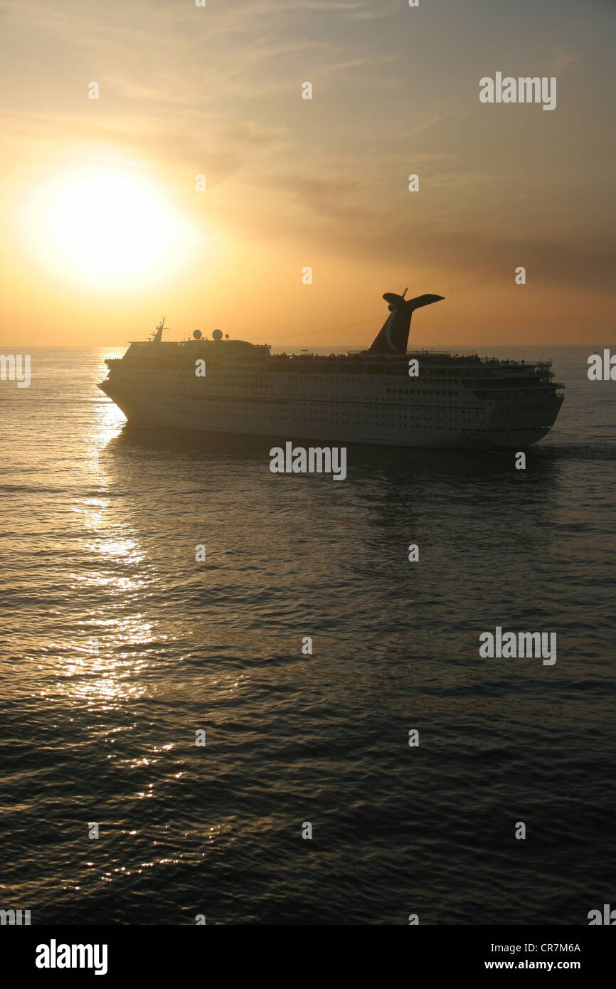 Un navire de croisière Carnival quitte la ville portuaire d'Ensenada au Mexique au crépuscule. Banque D'Images