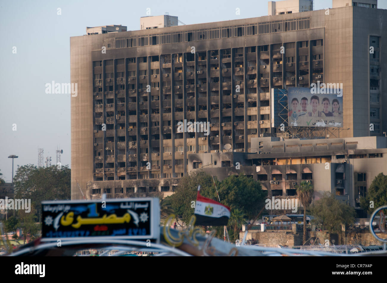 Brûlé de l'administration centrale du parti néo-démocrate au Caire en Égypte et en face d'un bateau de tourisme avec panneau "l'Égypte est numéro un" Banque D'Images
