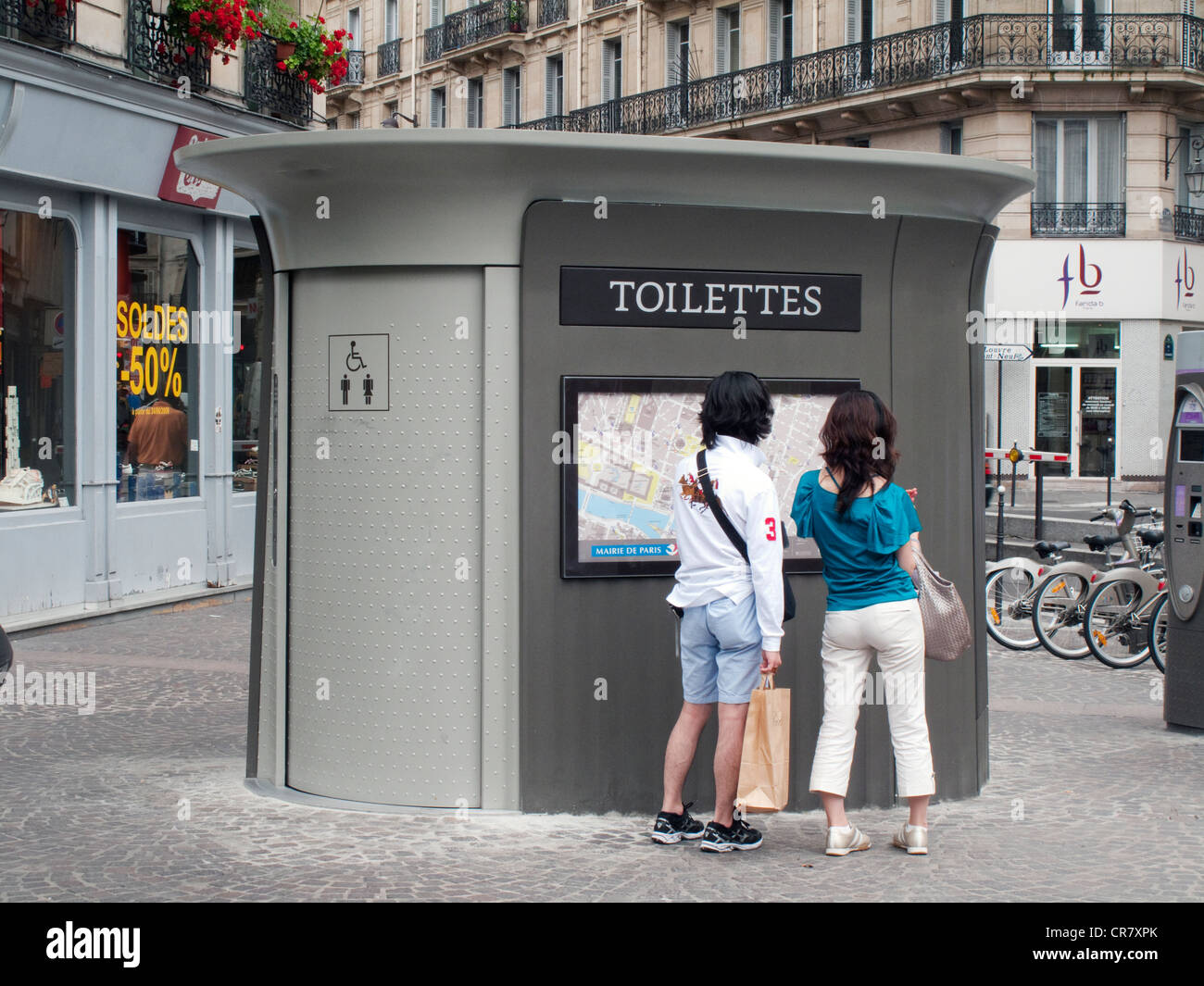 France, Paris, les toilettes publiques et tourist couple en regardant une carte du quartier des Halles Banque D'Images