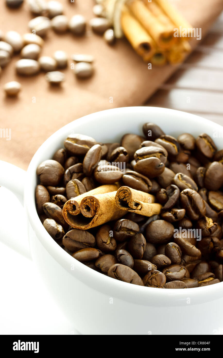 Les grains de café et les bâtons de cannelle dans la tasse Banque D'Images