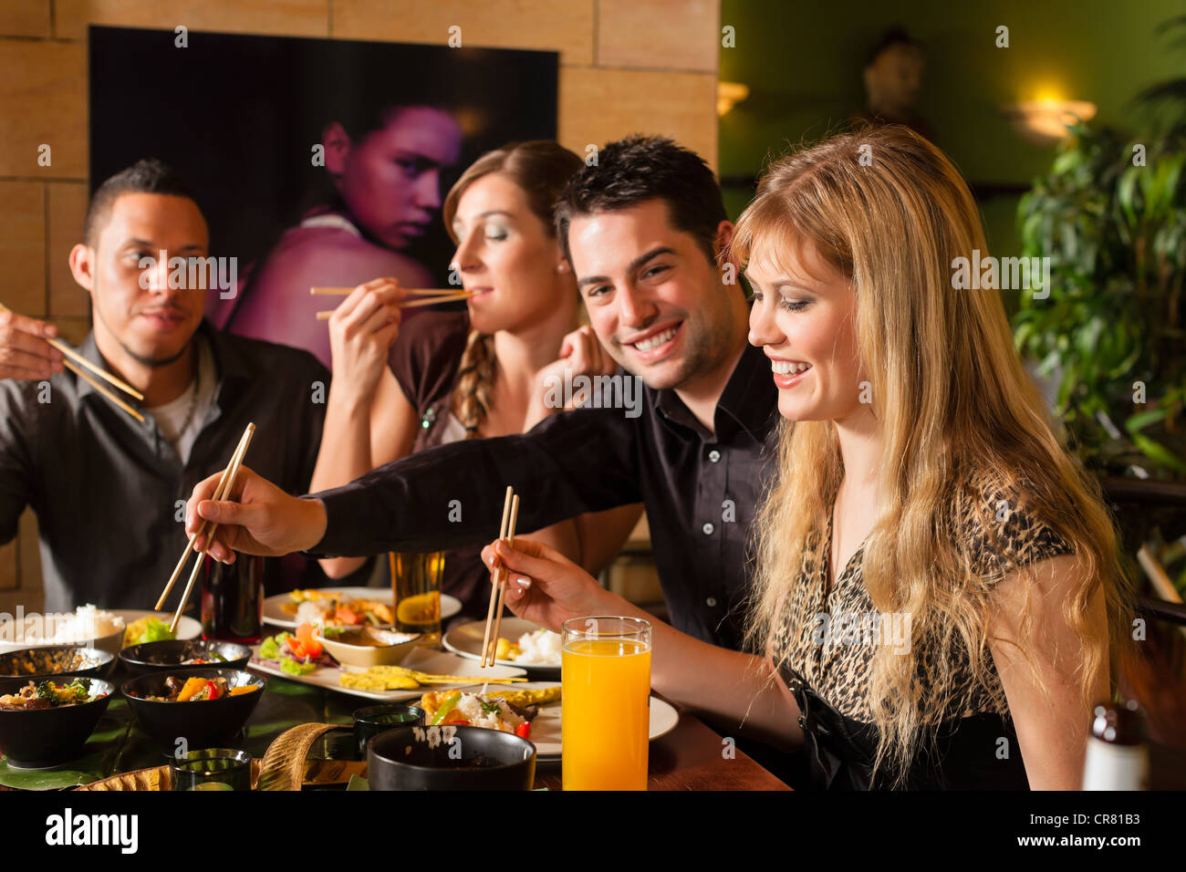 Les jeunes de manger dans un restaurant thaïlandais, ils mangent avec des baguettes Banque D'Images