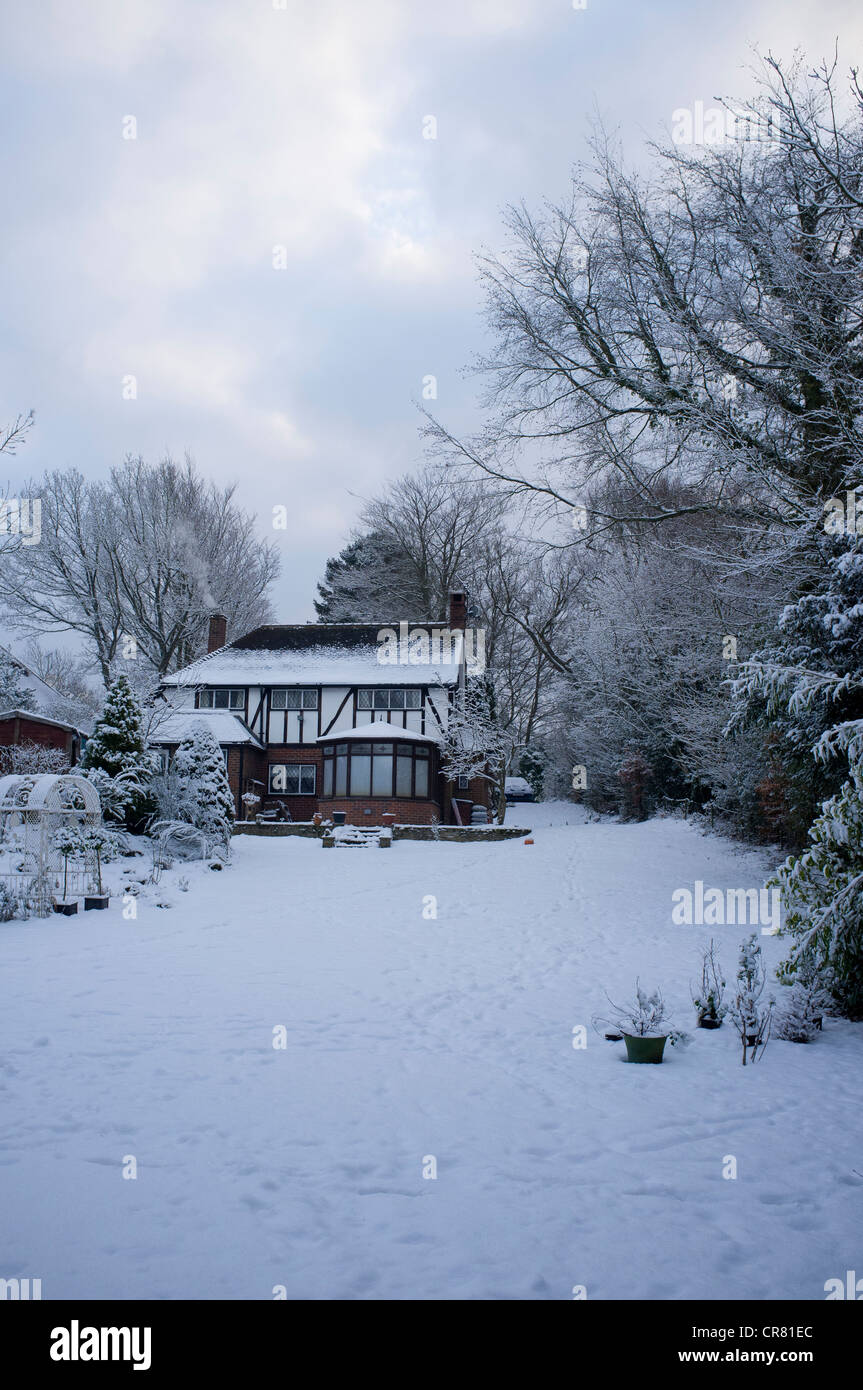 Un pays couvert de neige et le jardin cottage avec des immeubles Banque D'Images