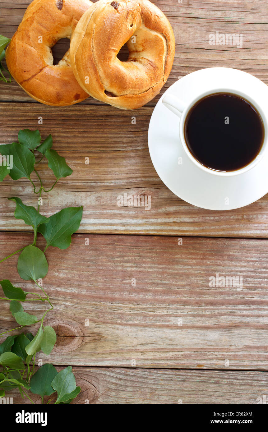 Tasse de café chaud avec des bagels sur gifles en bois rustique avec copyspace Banque D'Images