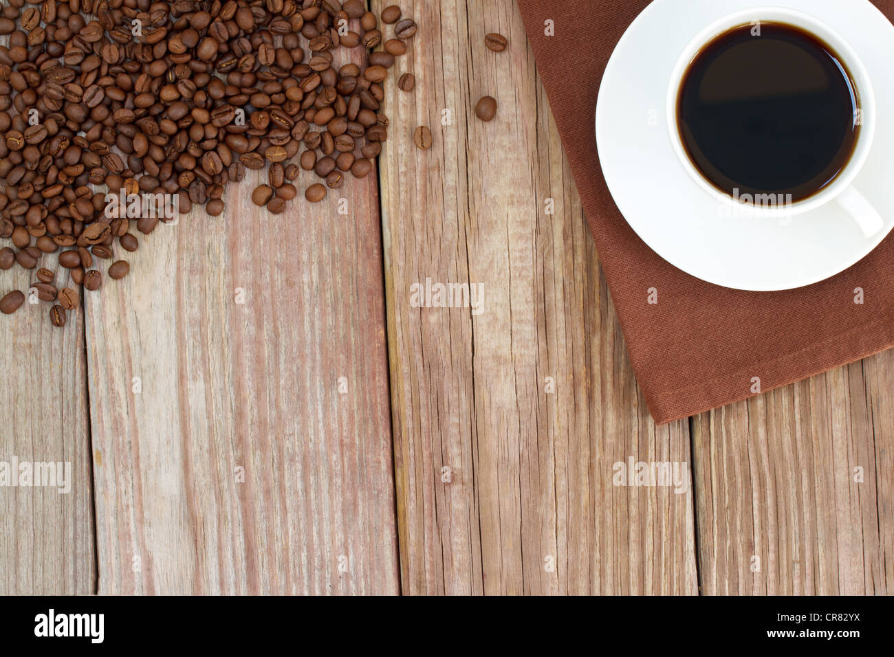 Tasse de café chaud avec café en grains sur les gifles en bois rustique avec copyspace Banque D'Images