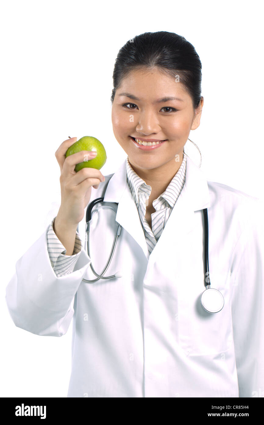 Femme médecin asiatique tenant une pomme. Banque D'Images