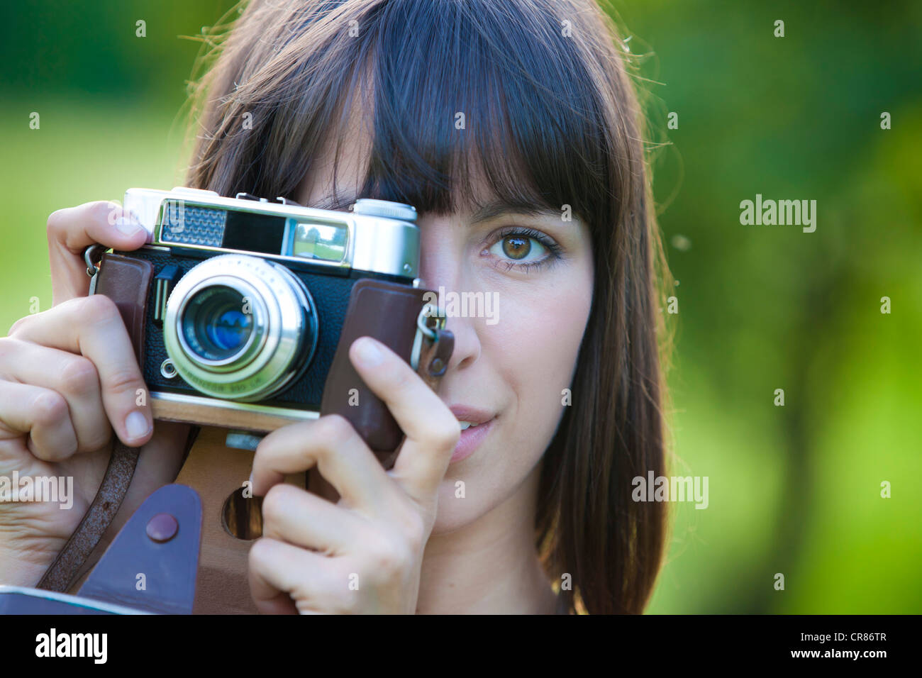 Jeune femme, 25 ans, titulaire d'un ancien appareil photo Banque D'Images