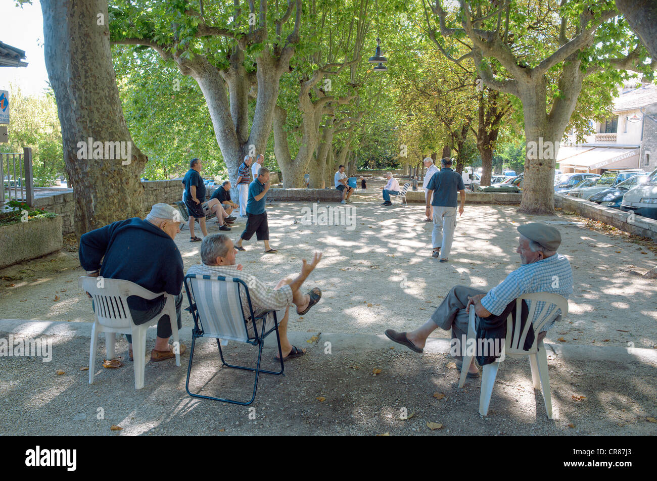 La France, Gard, Barjac, jeu de boules en été sur la place du marché à l'ombre des platanes Banque D'Images