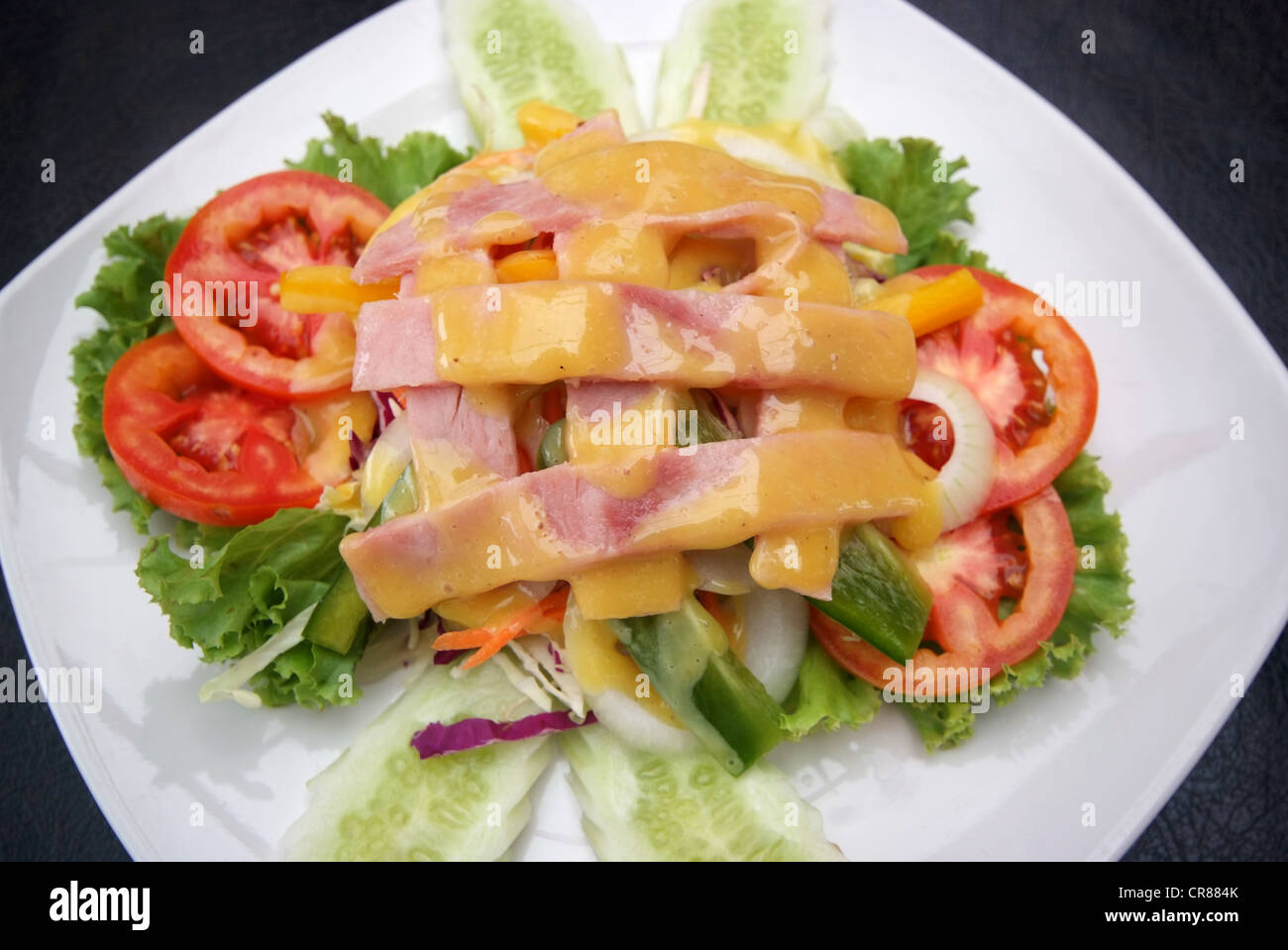 Salade de jambon avec des légumes sur plaque blanche. Banque D'Images