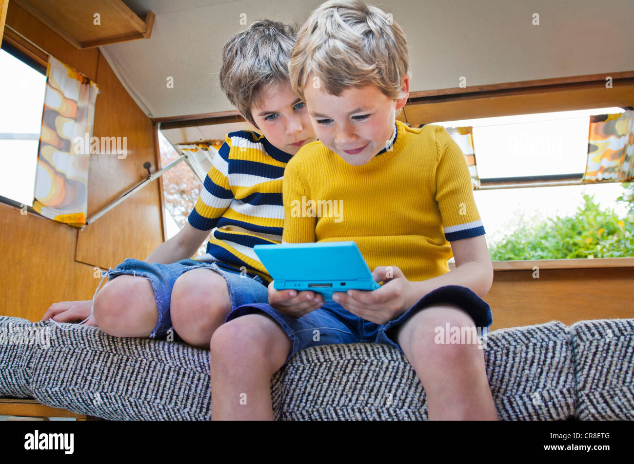 Deux jeunes garçons jouent au jeu vidéo de poche Banque D'Images