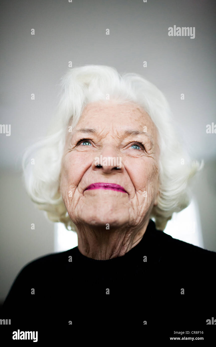Portrait of senior woman looking up, studio shot Banque D'Images