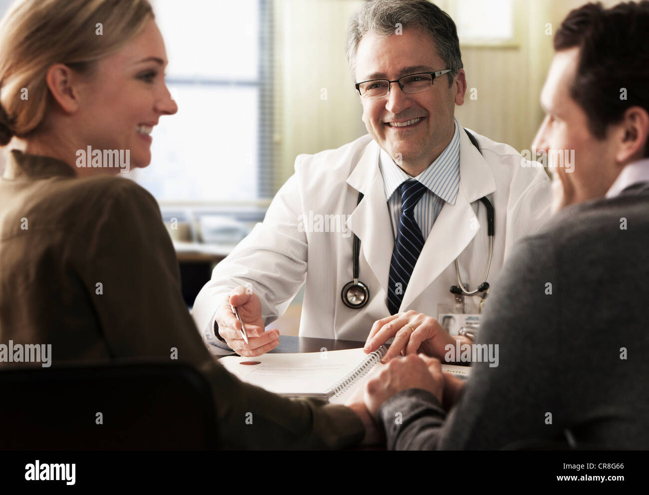 Jeune couple dans le cabinet du médecin de recevoir de bonnes nouvelles Banque D'Images