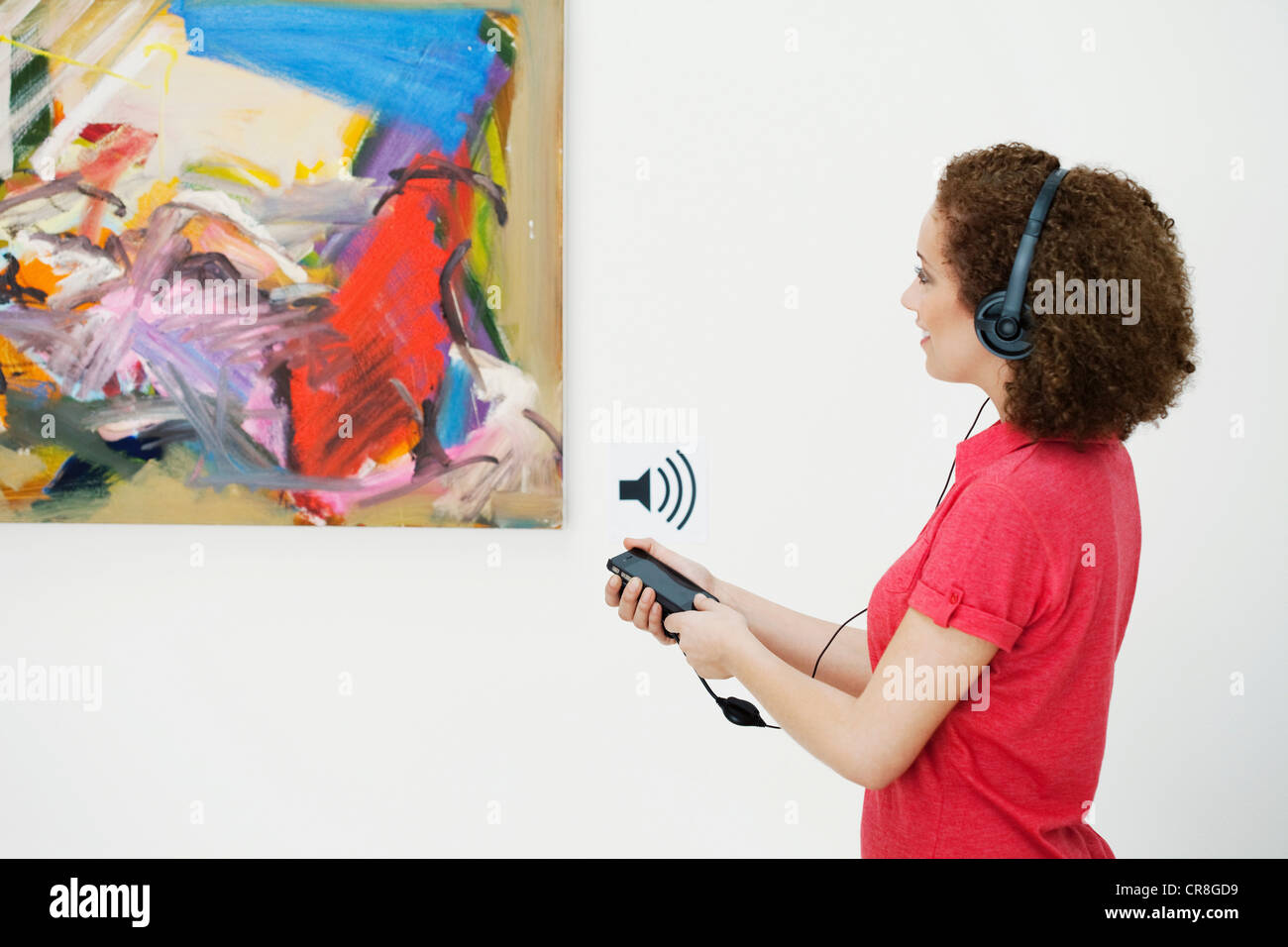 Jeune femme à l'aide d'audio-guide dans l'art gallery Banque D'Images